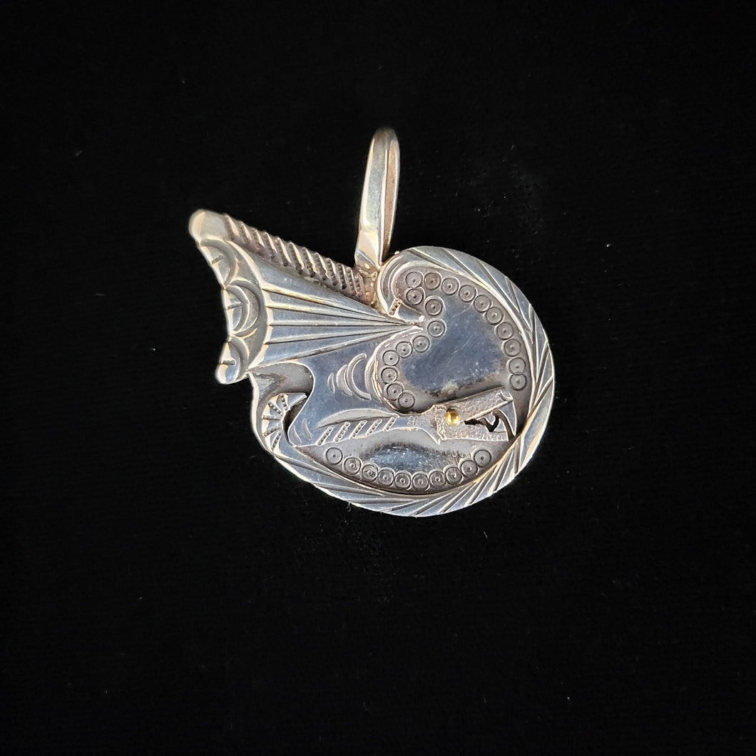 Sterling silver dragon pendant with a gold eye by artist Tim Terry