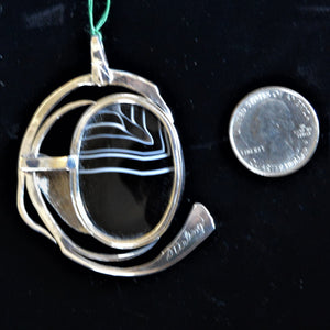 Back of pendant with coin for size reference